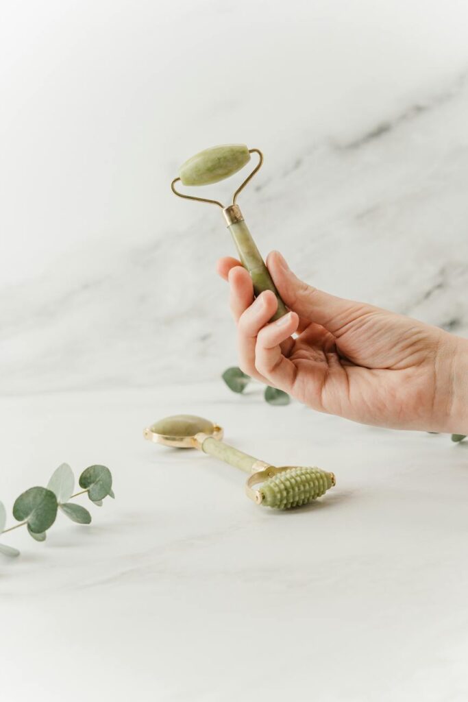 person holding silver spoon with white flower petals