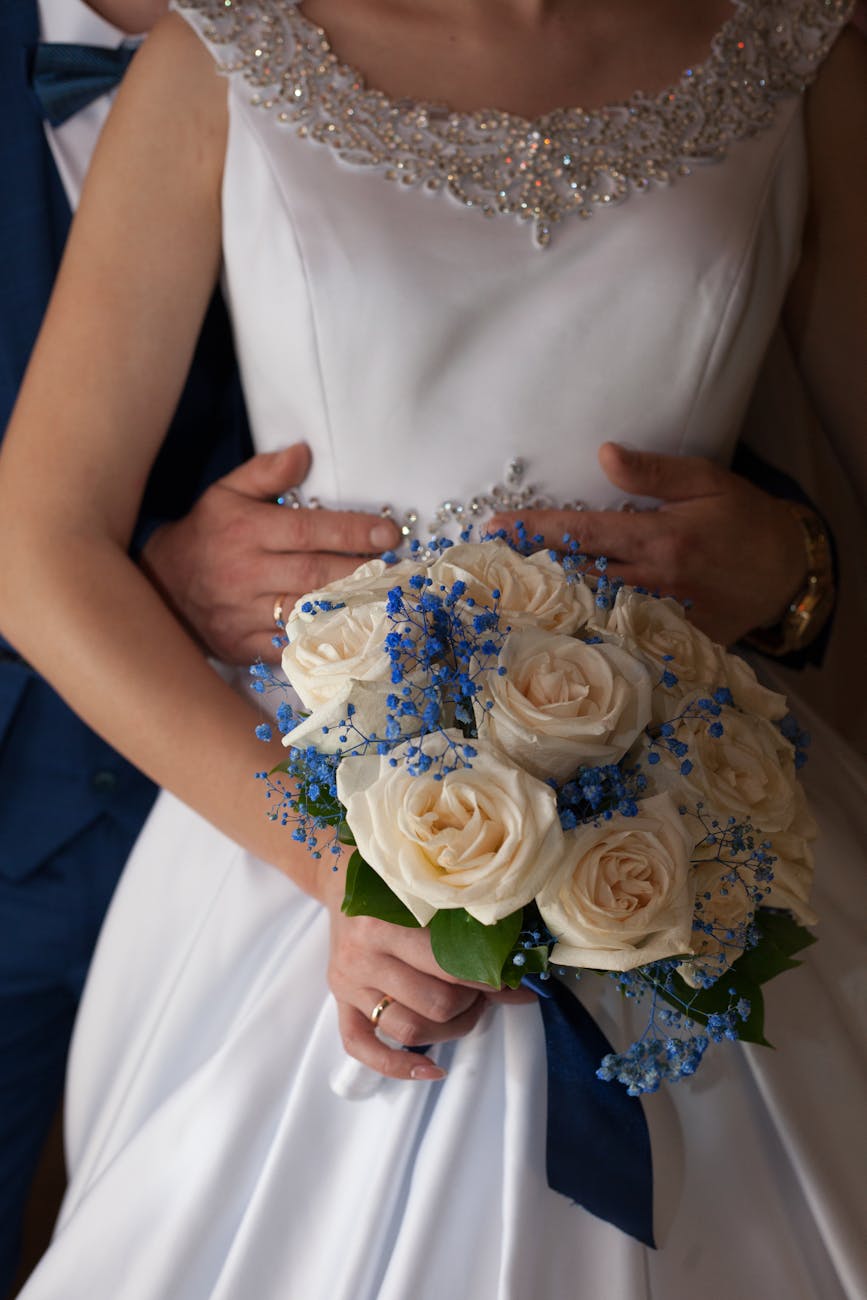 groom holds the waist of bride holding a bouquet