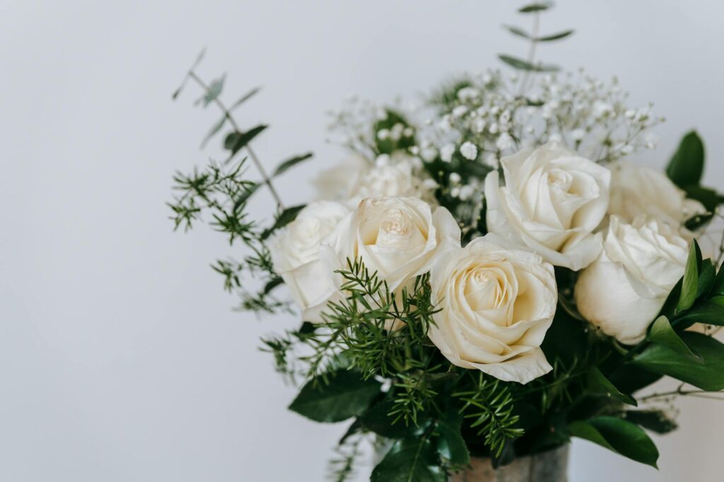 white gentle roses with fresh green leaves