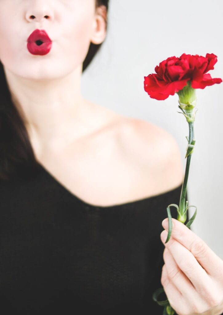 photo of a woman holding red carnation flower